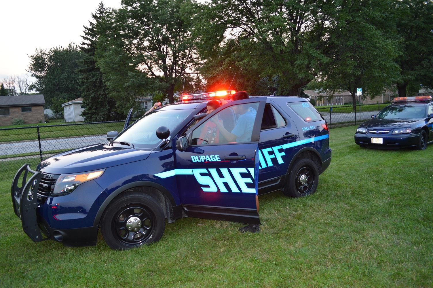 Children take turns looking through binoculars from a DuPage County Sheriff's vehicle during a National Night Out event at the Iowa Community Center, Aug. 2.